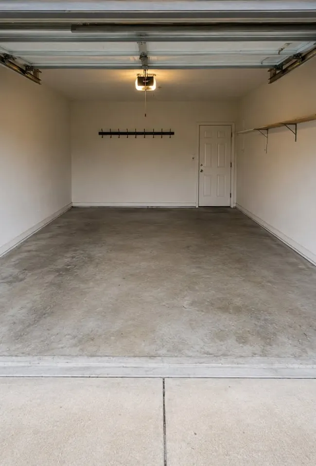 Single-car garage cleared to bare concrete after a full cleanout